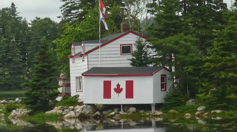 white and red wooden house near body of water during daytime