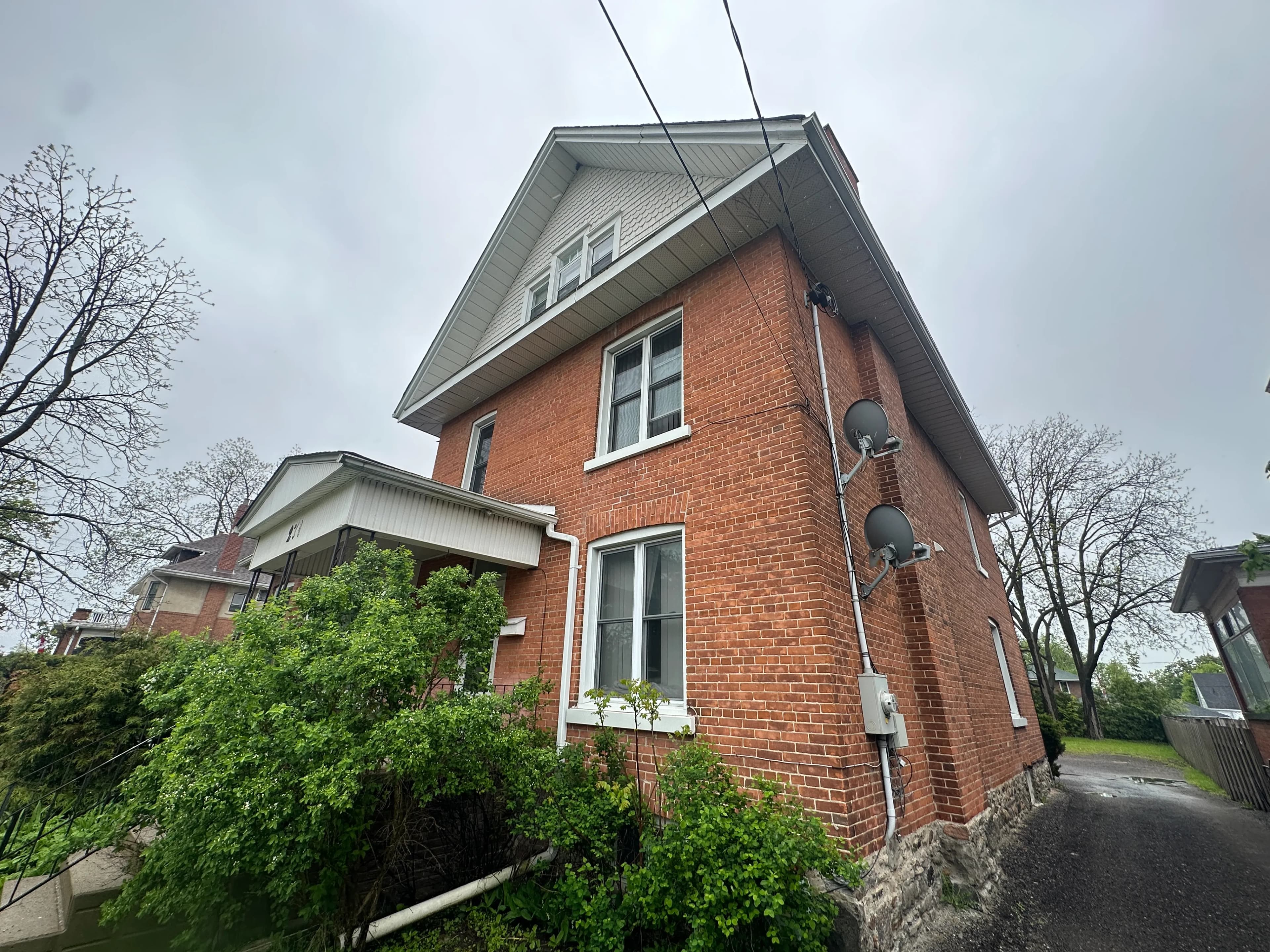 Ontario house with charred siding and boarded windows after a residential fire