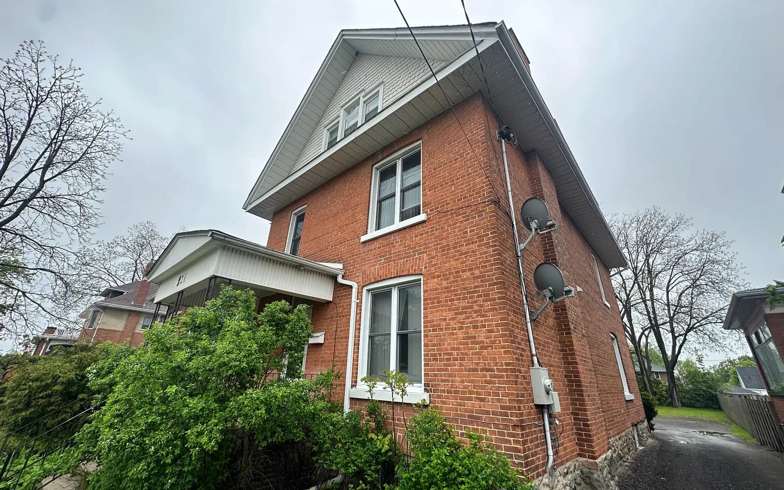 Red-brick two-and-a-half-storey home on a leafy street in Aurora, Ontario