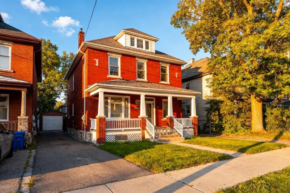 Brick two-storey home on a new subdivision street at golden hour in New Tecumseth, Ontario