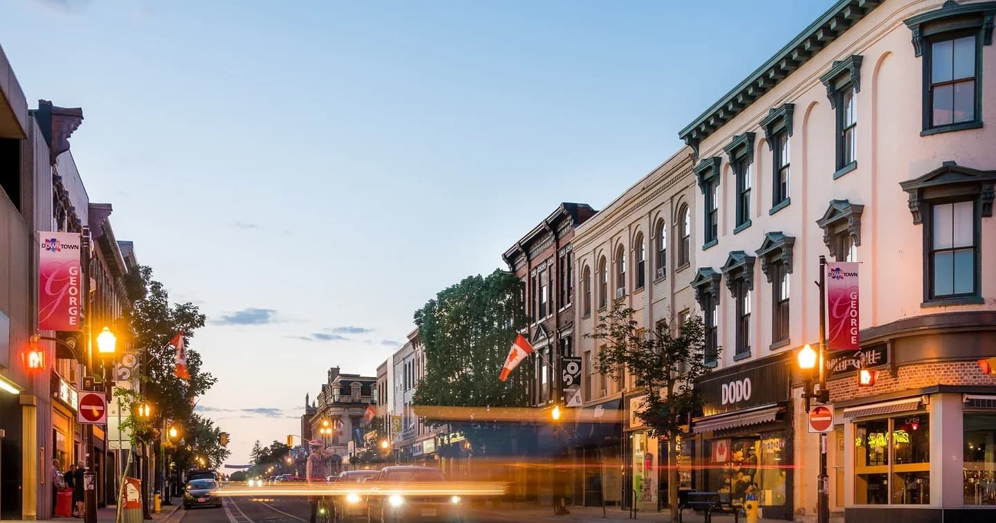 Historic downtown main street at dusk with heritage brick storefronts and street banners