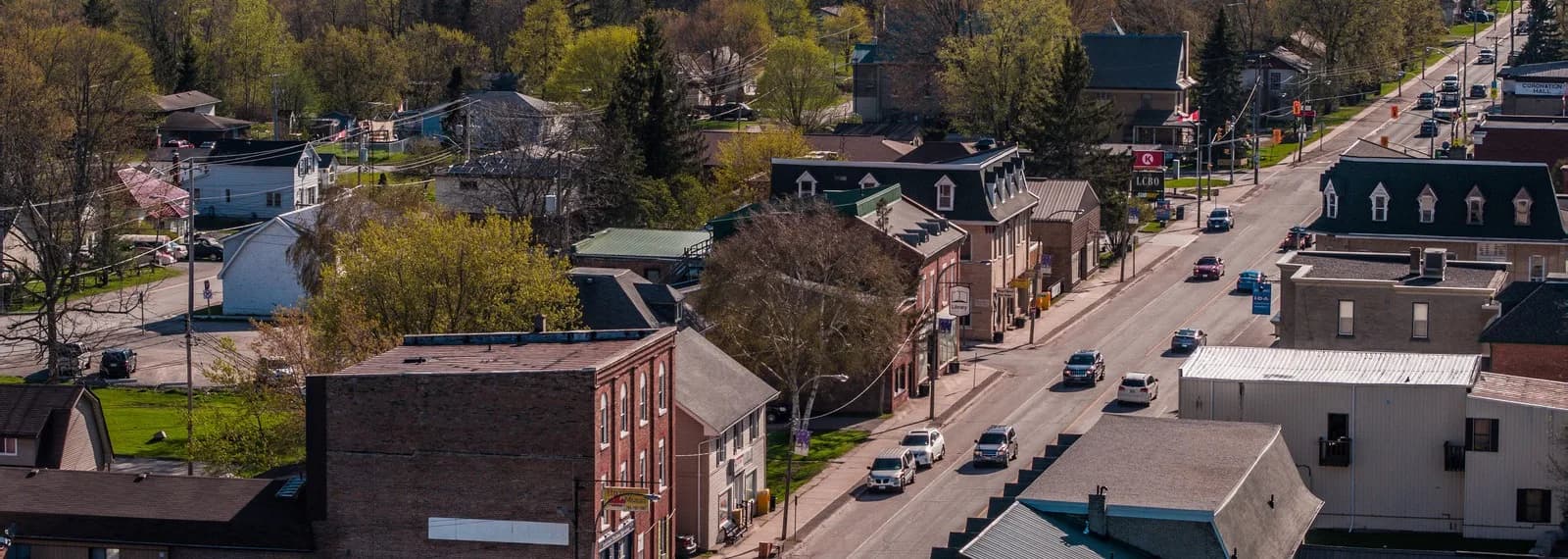 Aerial view of Omemee's main street along Highway 7, lined with brick storefronts and Coronation Hall