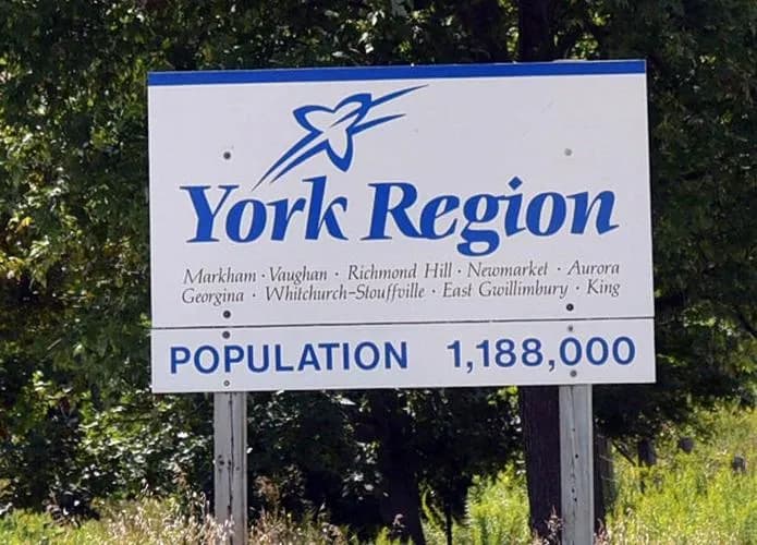 York Region welcome sign listing its nine municipalities beside a rural road