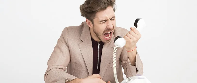 man holding telephone screaming