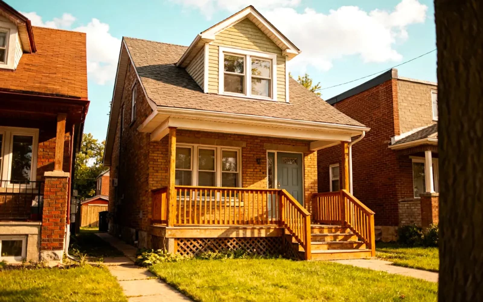 Yellow-brick bungalow with a covered front porch at golden hour in Angus, Ontario