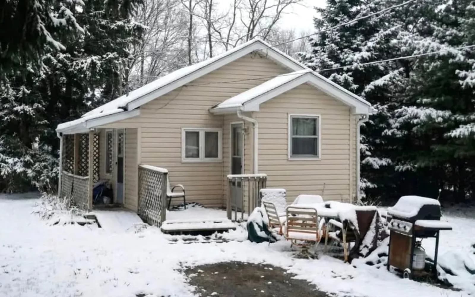 Beige bungalow with a deck on a snowy wooded lot in Brampton, Ontario