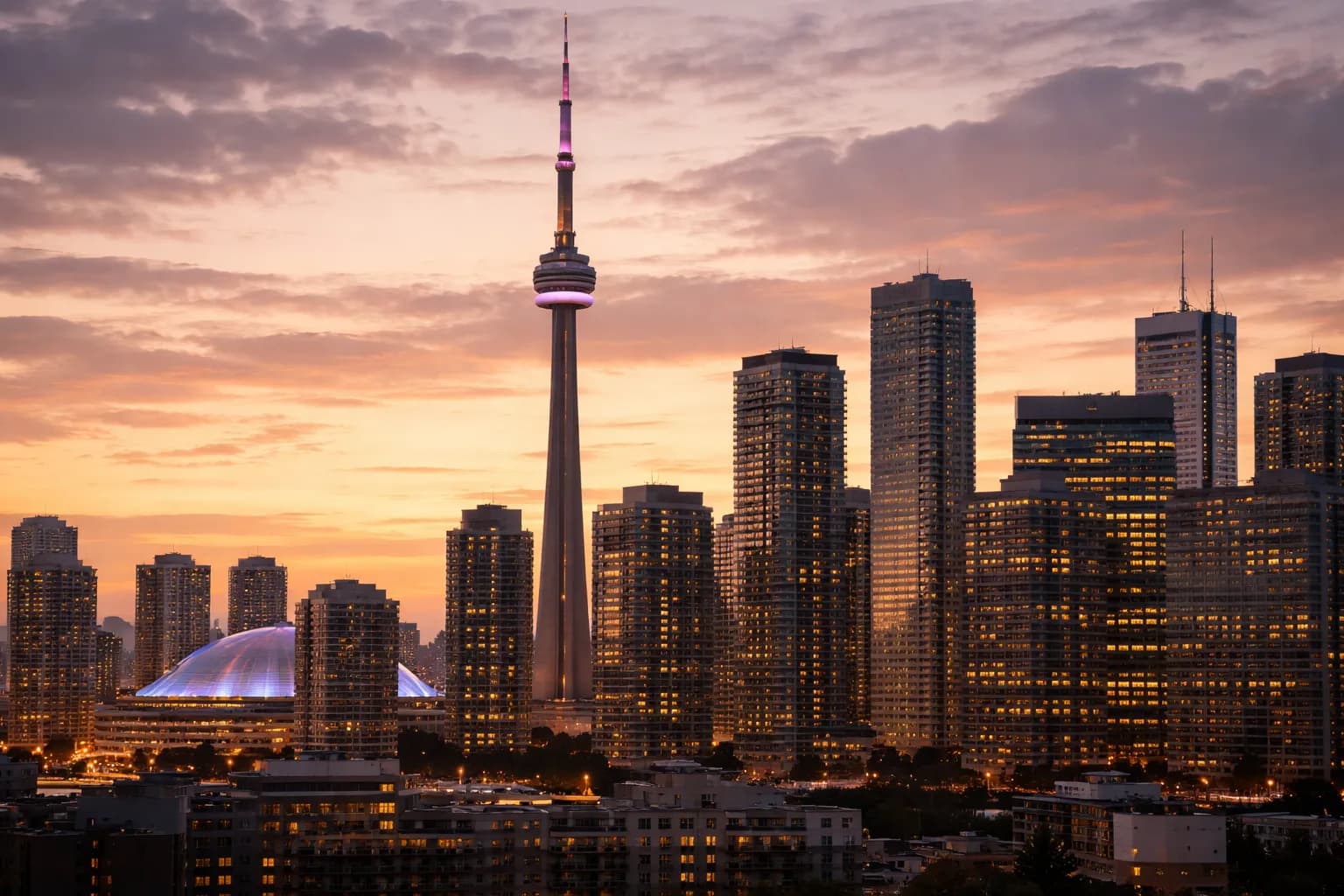 Toronto skyline with the CN Tower at sunset behind GTA condo towers